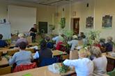 Seniorzy układają każdy swoją kokeadamę. Obwiązują sznurkiem bryłę korzeniową rośliny z ziemią i osłoniętą mchem.